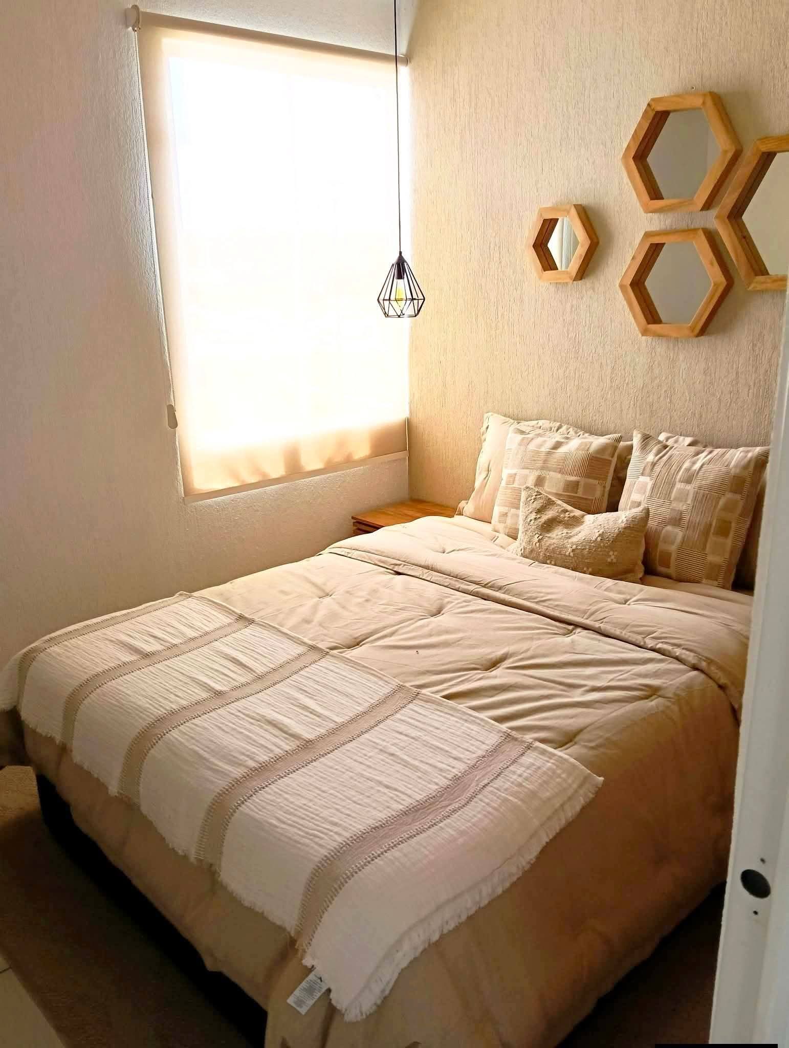 Recámara de departamento muestra con cama y decoración